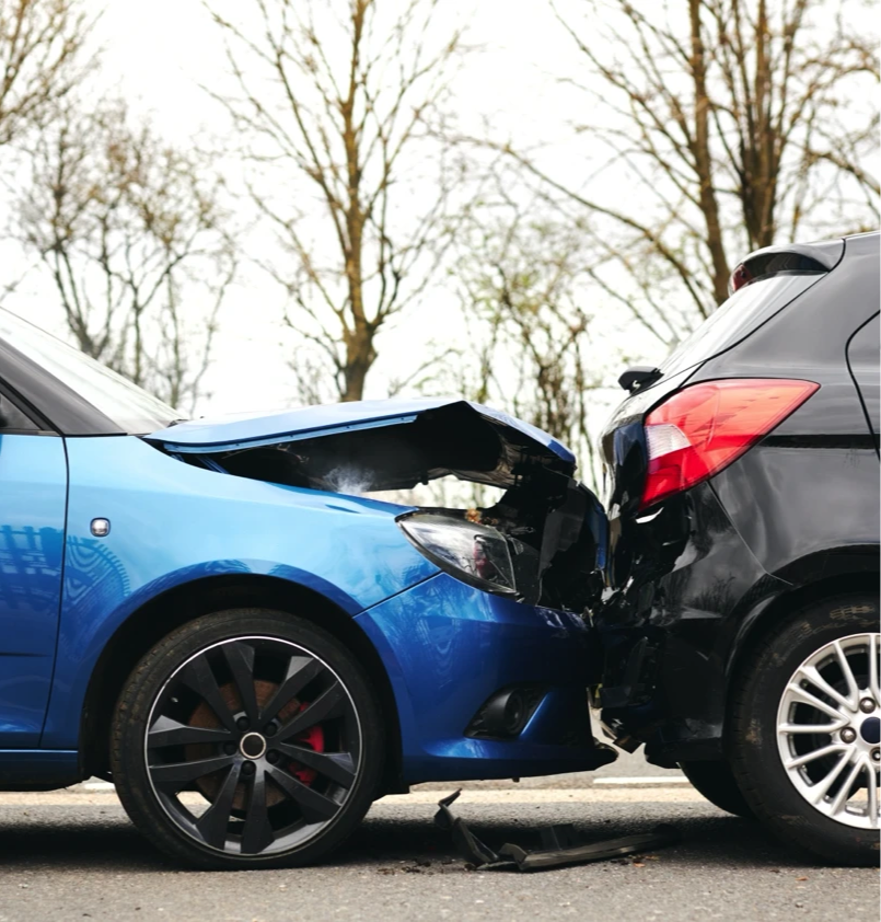 A car crash where a blue car rear ended a black car