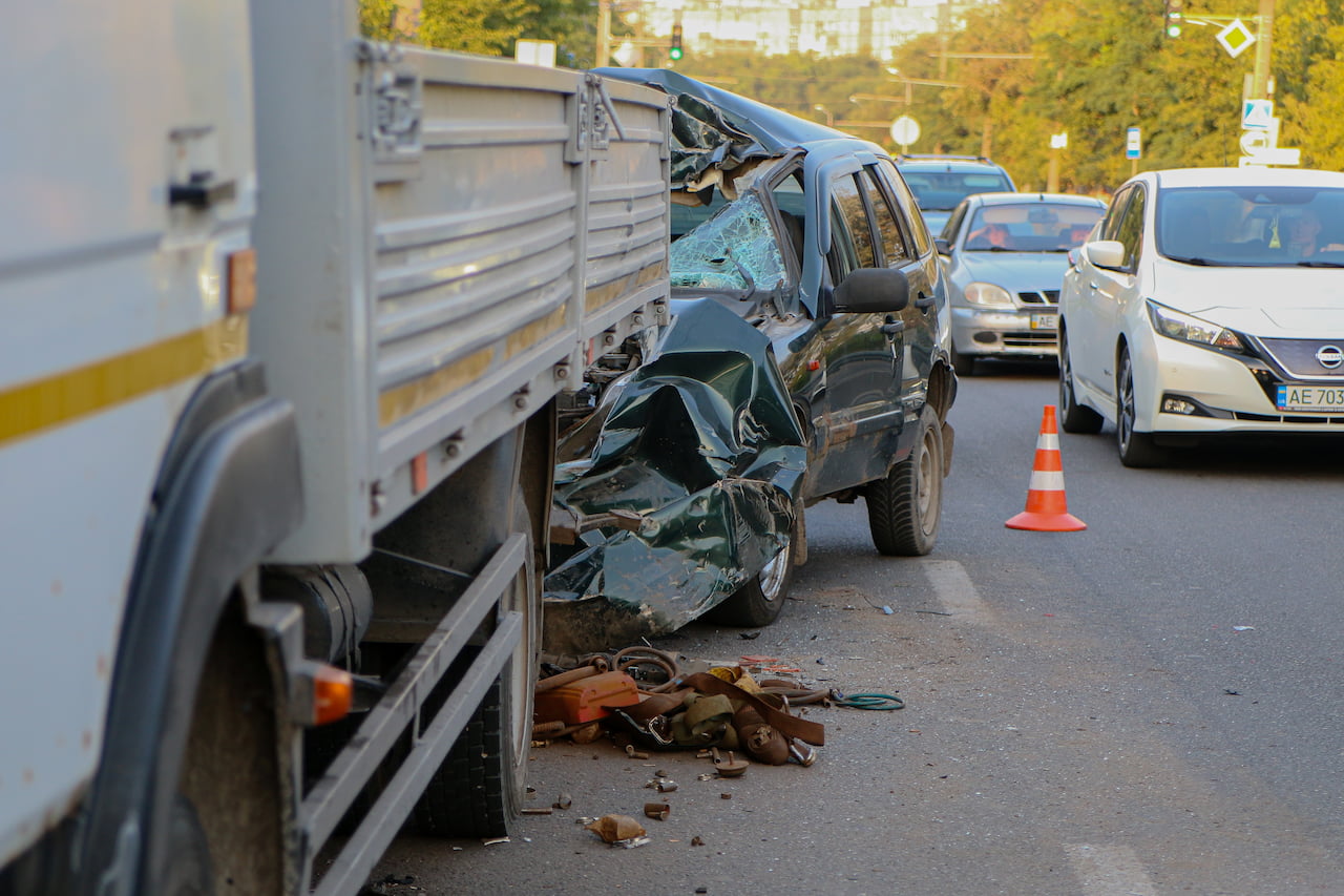 Shot of a damaged car after a head on collision with a commercial vehicle